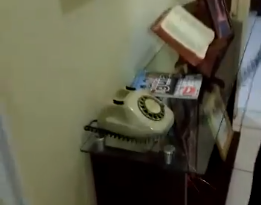 Jovem não consegue usar telefone antigo.