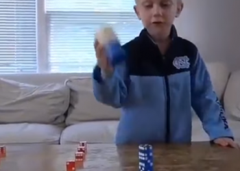 16 dados empilhados por uma criança de 5 anos.