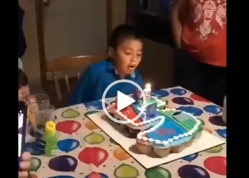 Garoto fica furioso no seu aniversário e vira o bolo sobre a mesa.